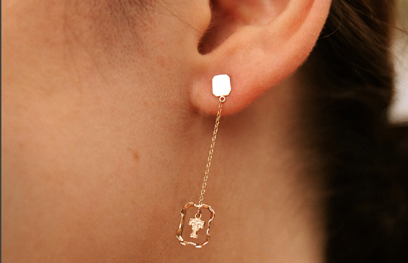 a woman wearing gold earring luxury jewelry